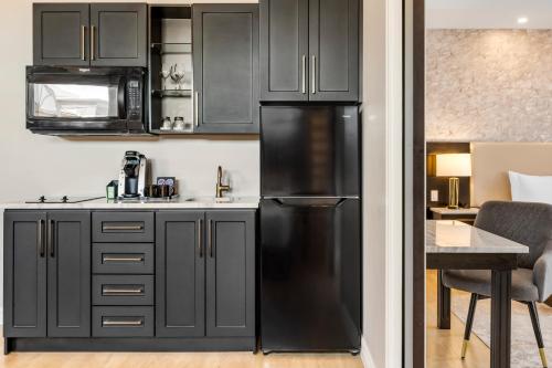 a kitchen with black cabinets and a black refrigerator at Halifax Tower Hotel & Conference Centre, an Ascend Collection Hotel in Halifax