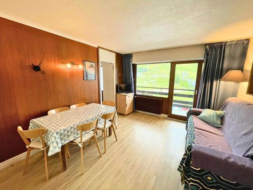 une pièce avec une table, des chaises et un lit dans l'établissement Résidence Oisans - Appartement 2 pièces pour 6 personnes balcon exposé Sud MAE-4824, aux Menuires
