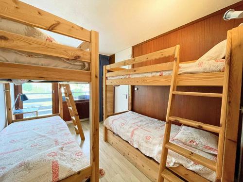 une chambre avec deux lits superposés et un lit dans l'établissement Résidence Oisans - Appartement 2 pièces pour 6 personnes balcon exposé Sud MAE-4824, aux Menuires