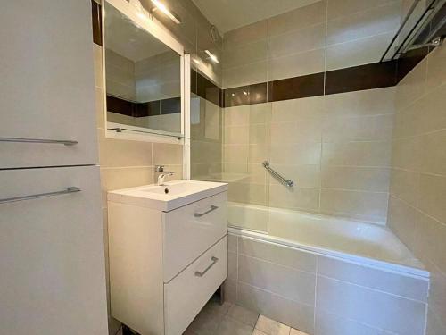 une salle de bain blanche avec un lavabo et une baignoire dans l'établissement Résidence Oisans - Appartement 2 pièces pour 6 personnes balcon exposé Sud MAE-4824, aux Menuires