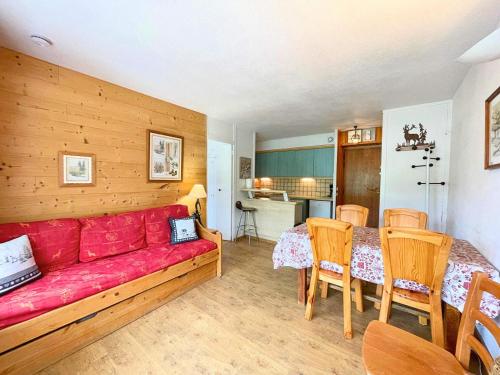 un salon avec un canapé rouge et une table dans l'établissement Résidence Oisans - Appartement 2 pièces pour 5 personnes MAE-4954, aux Menuires