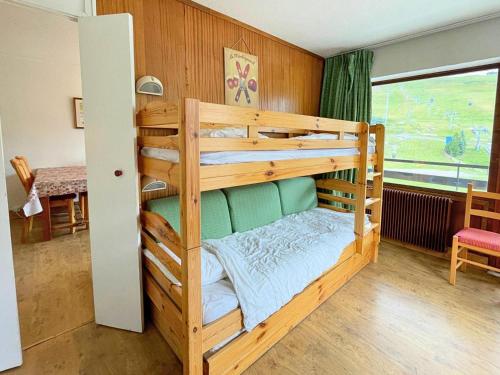Ce lit superposé en bois se trouve dans un dortoir doté d'une fenêtre. dans l'établissement Résidence Oisans - Appartement 2 pièces pour 5 personnes MAE-4954, aux Menuires