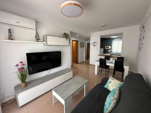 un soggiorno con un divano e una TV di Apartamento SERENITY Nerja a Nerja