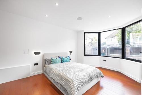 1 dormitorio con paredes blancas y 1 cama con almohadas azules en Homestay, en Hendon