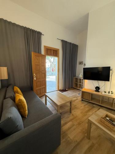 a living room with a couch and a flat screen tv at Casas La Aldea Suites Plaza in La Aldea de San Nicolas