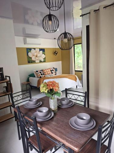 a dining room with a table with chairs and a bed at Cabañas Mantas in Tarcoles