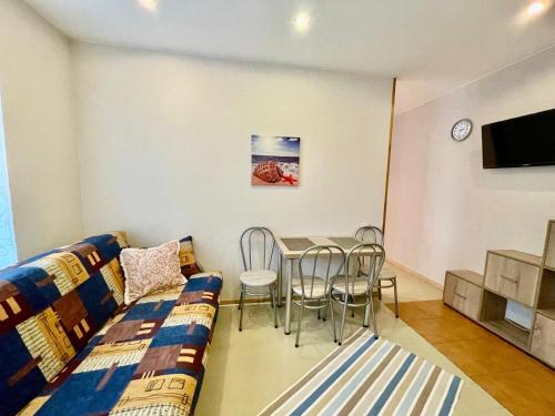 a living room with a couch and a table and chairs at ''Rozā namiņš'' in Ventspils