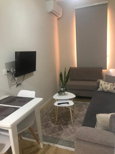 - un salon avec un bureau blanc et un canapé dans l'établissement Home Inn Apartaments Tirana, à Tirana