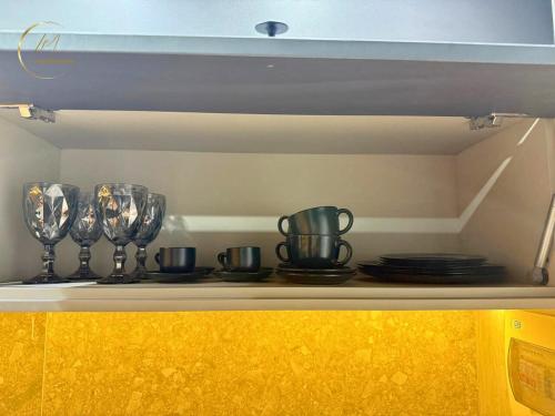 a shelf with wine glasses and plates on it at LM Setai Yacht Cabo Branco in Tambaú