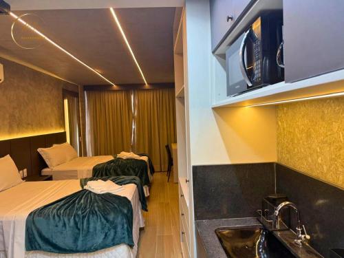two beds in a room with a sink and a bathroom at LM Setai Yacht Cabo Branco in Tambaú