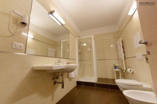 a bathroom with a sink and a toilet and a mirror at San Severino Park Hotel & SPA, BW Signature Collection in Mercato San Severino