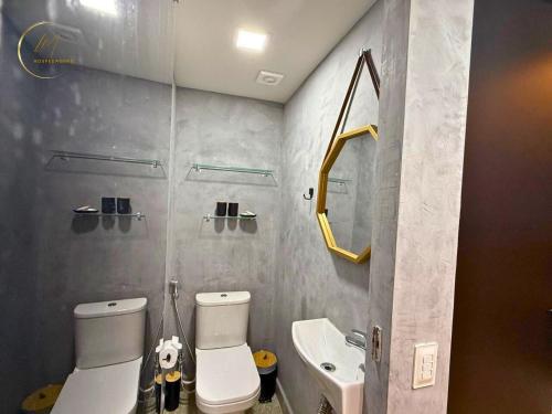 a bathroom with a toilet and a sink and a mirror at LM Setai Yacht Cabo Branco in Tambaú