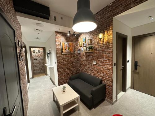 a living room with a couch and a brick wall at Affordable Luxury Capsule Bed in Downtown Dubai Near Metro in Dubai