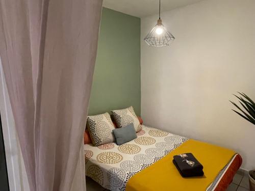 a small bedroom with a bed with a yellow blanket at Les Studios de la Bastide in Carcassonne