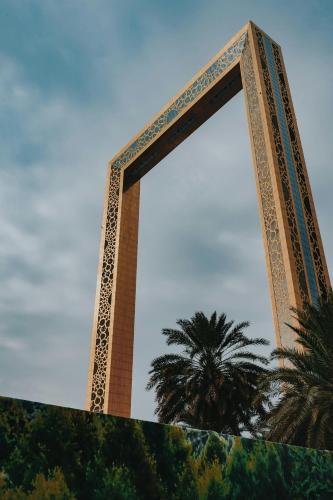 a tall building with a palm tree in the background at Affordable Luxury Capsule Bed in Downtown Dubai Near Metro in Dubai