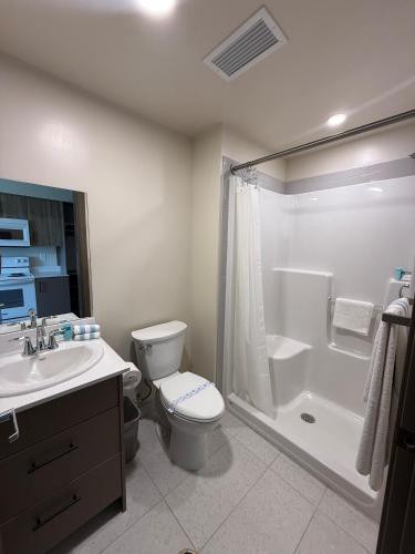 a bathroom with a toilet and a shower and a sink at Residence & Conference Centre - Kelowna in Kelowna