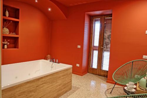 a bathroom with orange walls and a tub at Casa Barlotti Residenza di Campagna in Paestum
