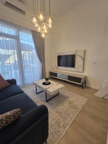 a living room with a blue couch and a tv at Lux Studio Porto in Tivat