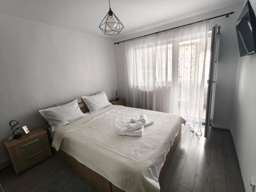 Un dormitorio con una cama con un animal de peluche encima. en Emily Apartment, en Alba Iulia