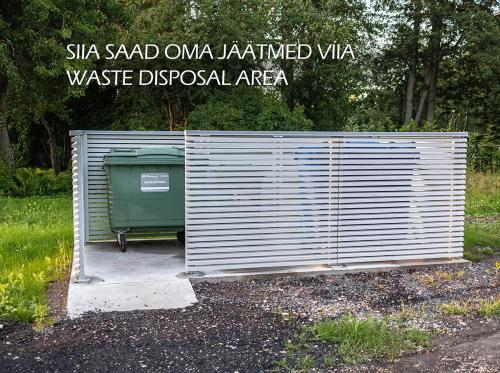 a shed with a trash can next to a sign at 3-room homey apartment in Kärdla in Kärdla