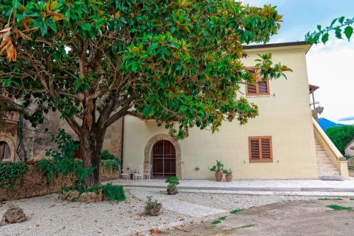 a house with a tree in front of it at Casa Barlotti Residenza di Campagna in Paestum