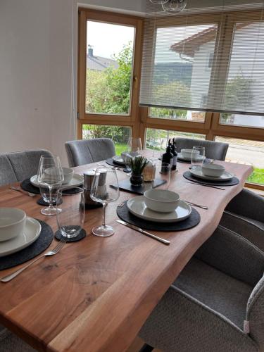 a wooden table with glasses and plates on it at Alpenruhe Kranzegg in Rettenberg