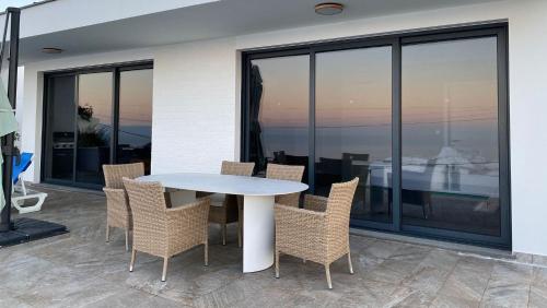 a white table and chairs on a patio at Villa Sundowner in Prazeres