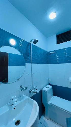 a bathroom with a white sink and a mirror at Karachi Inn in Karachi