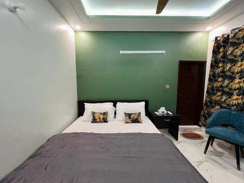 a bedroom with a bed and a blue chair at Karachi Inn in Karachi