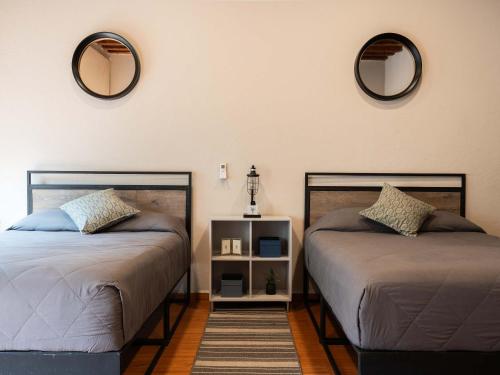two beds in a room with two mirrors on the wall at 104 Location 2Bdrm 2bath AC apt Fits 8 Rooftop in Mexico City