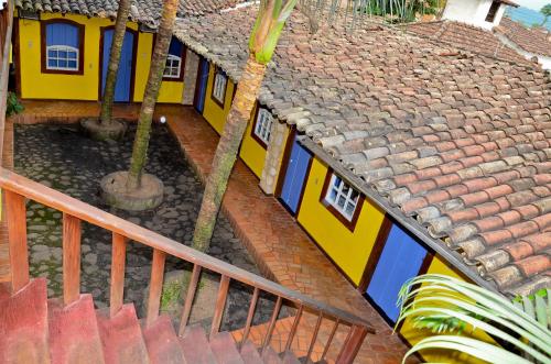 an overhead view of a yellow and blue building with palm trees at Pousada Konquista in Paraty