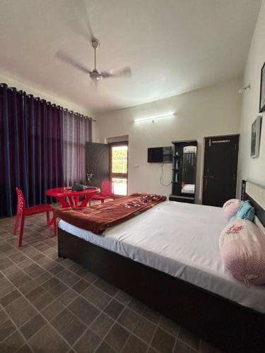 a bedroom with a large bed and a table at Varda farmstay in Thūr