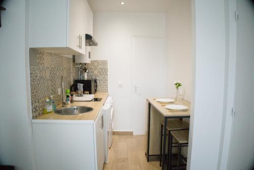 a small kitchen with a sink and a counter at Cosy T2 proche Orly & Paris Confort et Calme in Orly