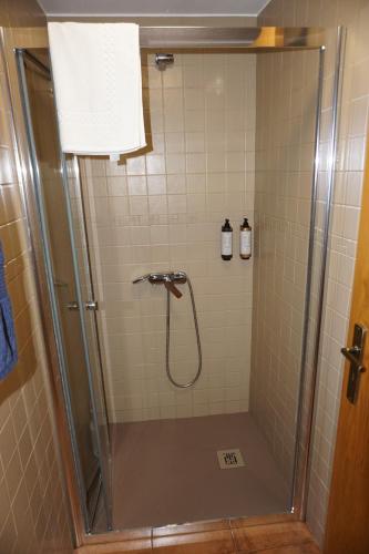 a bathroom with a shower with a glass door at Casa de Gondramaz - Galeria com Vista Serra in Miranda do Corvo