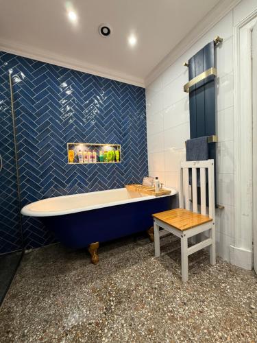 a blue bathroom with a tub and a table at Shannon River House & Gardens in Limerick