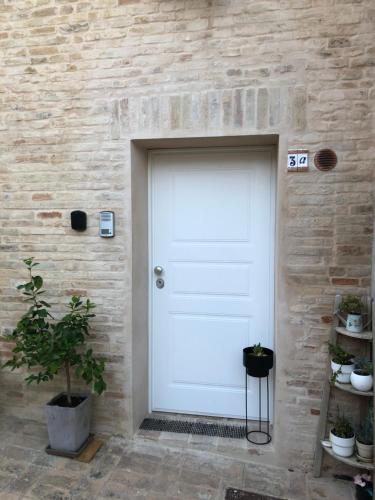 a white garage door on a brick wall at Alloggio nel Borgo 3a in Monte San Pietrangeli