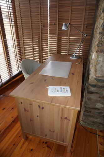 a wooden desk with a lamp on top of it at Casa de Gondramaz - Galeria com Vista Serra in Miranda do Corvo