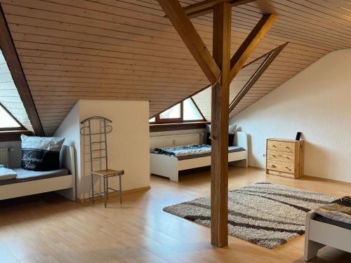 a attic bedroom with two beds and a wooden ceiling at Monteur Budget-Ferienhaus in Oggelshausen am Federsee nähe Biberach in Oggelshausen