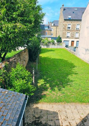 a grassy yard with a bench in front of a building at Le Blue Bohème in Fougères