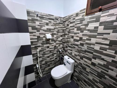 a bathroom with a toilet in a room with tiles at Karachi Inn in Karachi