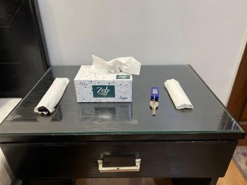 a black table with a box and a pair of scissors at Karachi Inn in Karachi