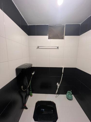 a black and white bathroom with a toilet at Karachi Inn in Karachi