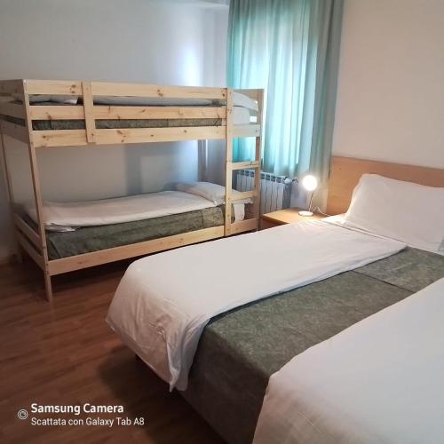 two beds in a room with two bunk beds at Life Hotels Des Alpes in Folgaria