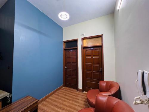 a room with two brown doors and a chair at Karachi Inn in Karachi