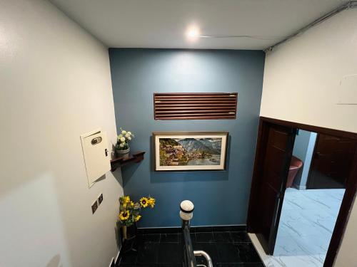 a hallway with a blue wall with a picture on it at Karachi Inn in Karachi