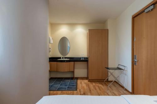 a bedroom with a sink and a mirror on the wall at Best Western Nairobi Upper Hill in Nairobi
