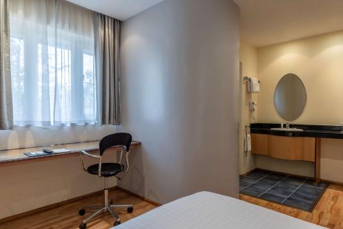 a room with a bed and a chair and a window at Best Western Nairobi Upper Hill in Nairobi