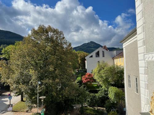 a building and a tree with mountains in the background at Kerschbaumer.Apartments in Waidhofen an der Ybbs