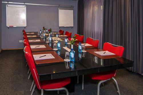 a conference room with a long table and red chairs at Best Western Nairobi Upper Hill in Nairobi