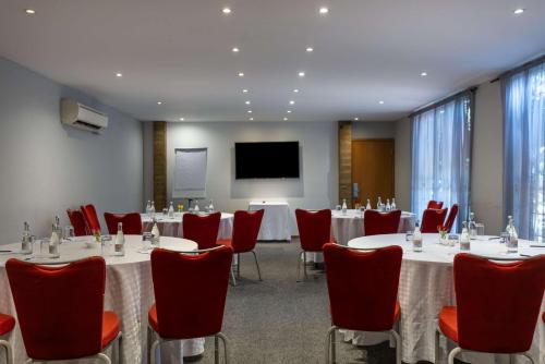 a conference room with tables and chairs and a screen at Best Western Nairobi Upper Hill in Nairobi